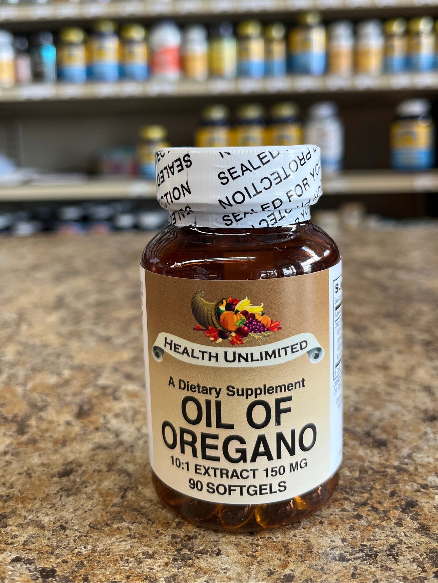 Bottle of Oil of Oregano on a stone surface with shelves in the background