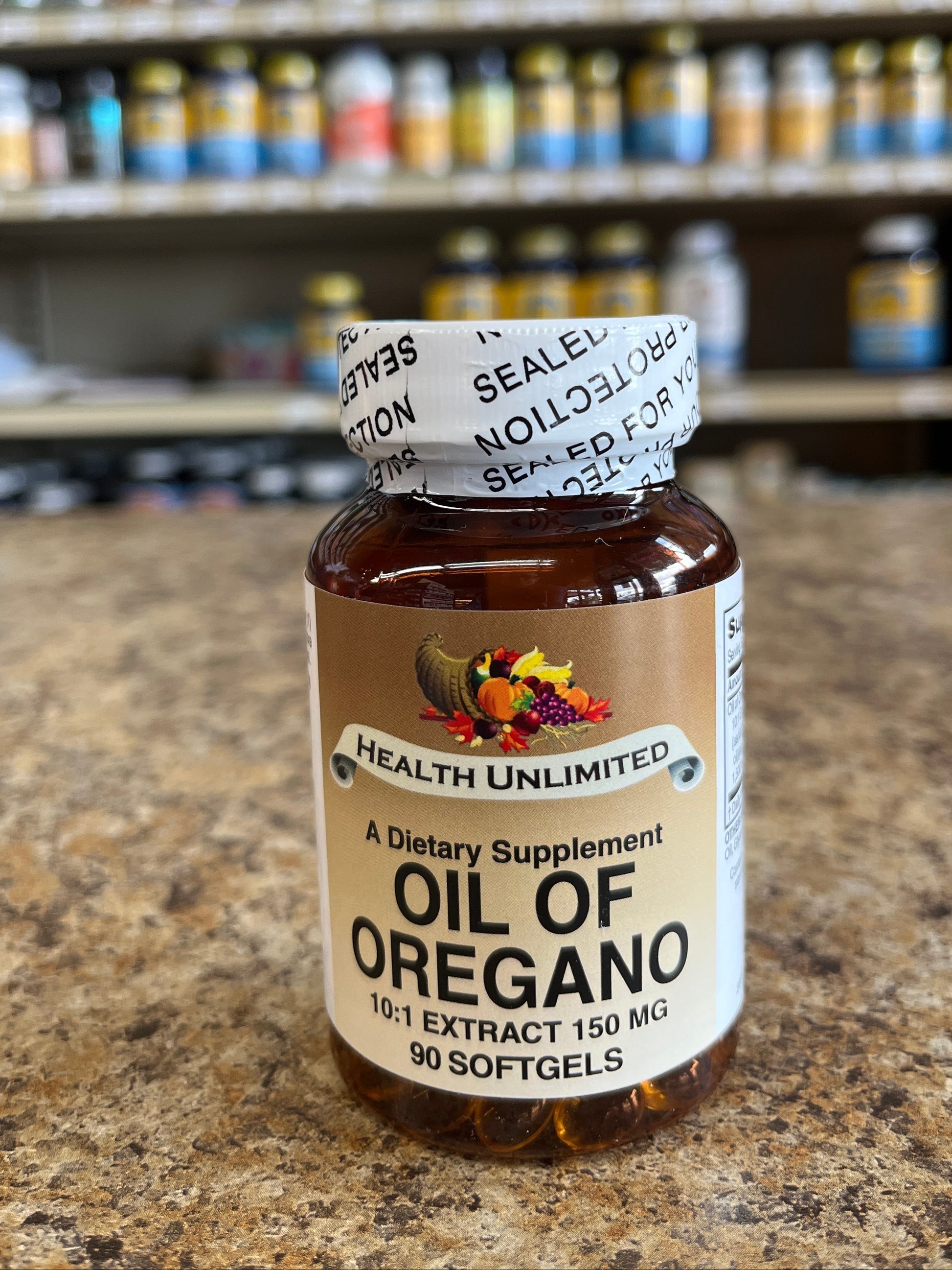 Bottle of Oil of Oregano on a stone surface with shelves in the background